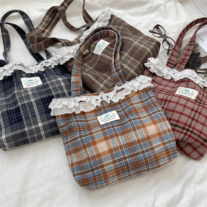 Detailed view of plaid tote bags with delicate lace trim and Happy patch labels