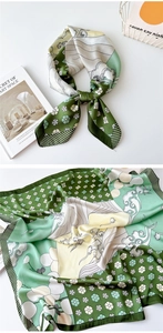 Detail of silk square scarf showing floral patterns, wave lines and green striped edges
