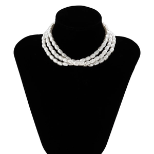 Detailed view of layered baroque pearl necklaces displayed on a black velvet mannequin bust