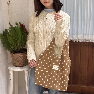 Close-up of brown polka dot tote bag with textile label and soft corduroy texture