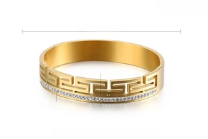 Detail of gold-plated stainless steel cuff with Greek key patterns and white zircons