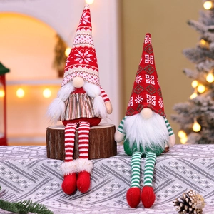 Close-up of two long-legged Christmas gnomes with striped knitting and festive decor