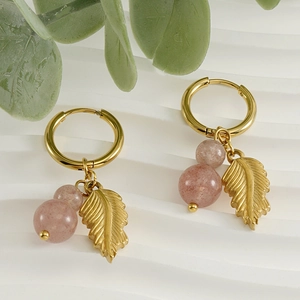 18K gold plated feather earrings with natural pink stone on a white wave stand