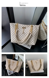 Dettaglio della grande borsa tote con motivo floreale, catena dorata e ciondolo cervo