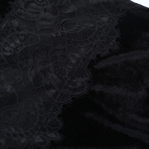 Gros plan détaillé sur la dentelle noire et le velours luxueux de la robe de soirée