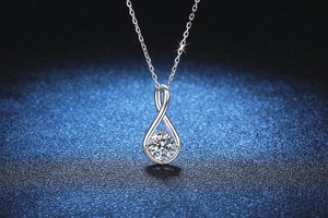 Macro view of water drop silver necklace with a brilliant round moissanite stone