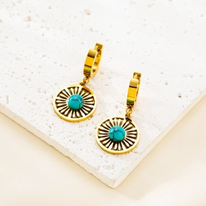 Golden stainless steel mesh earrings with round turquoise stone on stone background