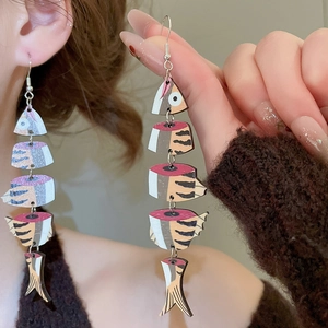 Detail of vintage ethnic fishbone earrings with wooden print pattern and tassel fringe