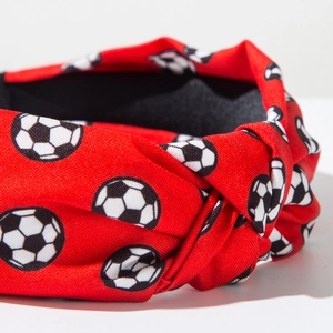 Detail eines roten geknoteten Stirnbands mit Fußballprint und hochwertiger Stoffstruktur