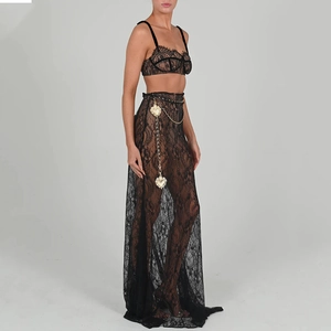 Detail of black lace two-piece set featuring a sheer maxi skirt and heart pendant chain belt