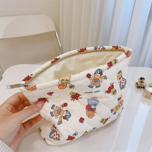 Detailed interior of a white quilted makeup bag with vintage floral prints and zip closure