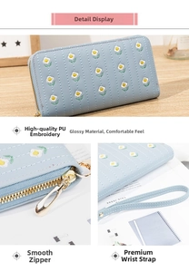 Detail of light blue PU wallet with daisy embroidery, smooth zipper, and wrist strap