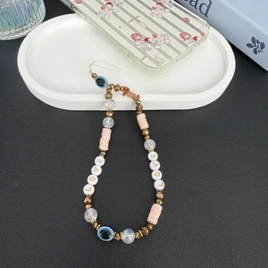 Detail of bohemian phone strap with pink clay beads, evil eye charm and LOVE lettering