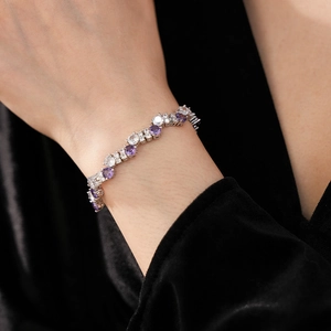 Detailed view of silver bracelet with sparkling purple zircons on a female wrist