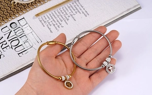 Detail view of cross pendant snake chain bracelets with magnetic clasp in gold and silver