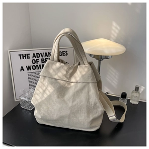 Close-up of cream nylon tote bag with pleated texture and wide shoulder strap