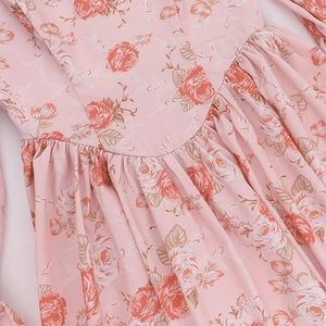 Gros plan d'une robe fleurie montrant la texture délicate et les plis de la taille