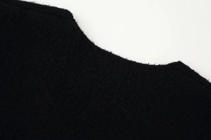 Detail view of V-neck collar and high-quality black knit fabric texture on women sweater