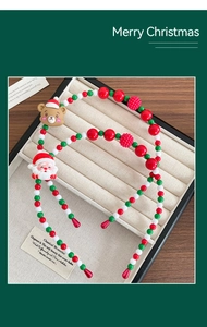 Detail of beaded Christmas headband featuring Santa and bear figures in a display box