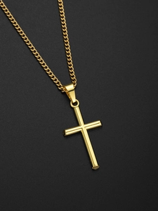 Gros plan d'un pendentif croix en or poli sur une longue chaîne sur fond sombre