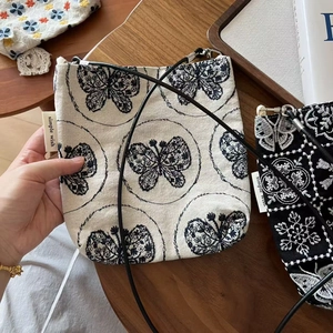 Gros plan détaillé des broderies florales exquises sur des sacs bandoulière en toile vintage