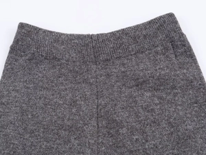 Primer plano detallado de la textura de punto gris y costuras de la cintura elástica