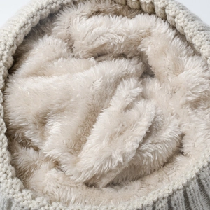 Detailed view of the thick beige fleece lining inside a warm winter knitted beanie hat