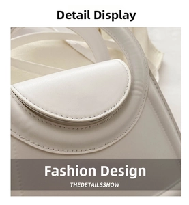 Detail of cream matte leather handbag featuring a round cutout handle and curved flap
