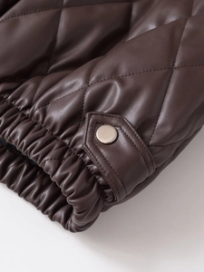 Détail de la veste en similicuir marron foncé avec poignets élastiques et boutons pression