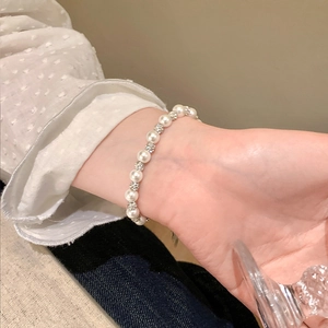 Elegant French style pearl and silver bead bracelet worn on a woman's wrist
