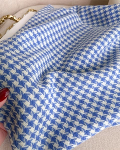 Close-up of blue and white houndstooth cashmere scarf showing soft texture and pattern