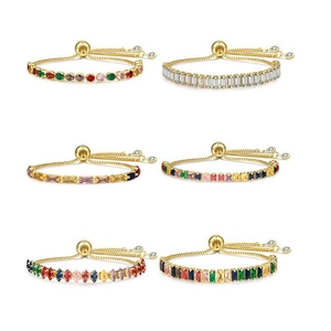 Detail of adjustable gold bracelets with various colorful gemstone cuts on white background