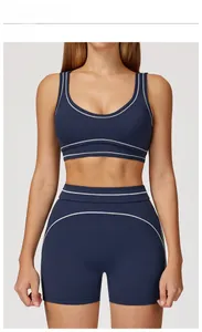 Close-up of navy yoga set featuring white contrast stitching on U-neck bra and shorts