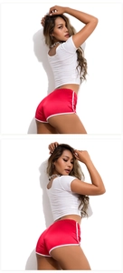 Detail view of red athletic shorts and white crop top for yoga and fitness training