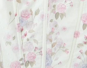 Detail of floral print under delicate white mesh with boning seams on corset top