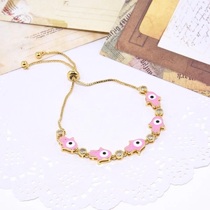 Detail of adjustable gold-plated Hamsa bracelet with pink enamel and sparkling zircon stones