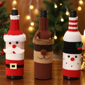 Three knitted Christmas wine bottle covers featuring Santa, snowman, and reindeer designs