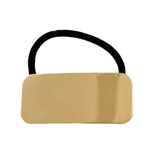 Close-up of a minimalist gold rectangular metal accent on a high-elastic black hair tie
