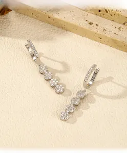 Macro shot of S925 sterling silver flower earrings with zircon tassels on stone props