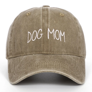 Close-up of white DOG MOM embroidery on a washed khaki distressed cotton baseball cap