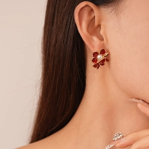 Vintage red flower stud earrings with pearl center on model for fashion look