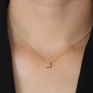 Close-up of a gold-plated necklace with a zircon-encrusted bubble letter H pendant