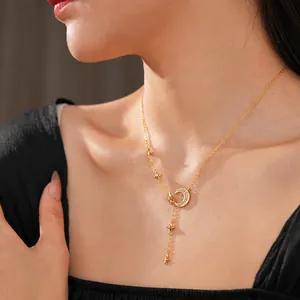 Y-shaped gold necklace with zircon moon and star pendants worn on a woman's collarbone