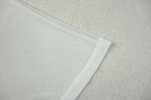 Close-up of white mesh fabric texture and flatlock stitching on the short sleeve dress