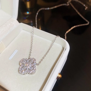 Detailed view of silver four-leaf clover pendant with sparkling cubic zirconia in jewelry box