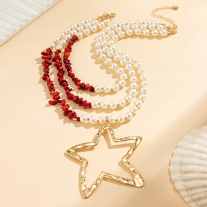 Detail of multi-layer beaded necklace featuring turquoise, pearls, and a star pendant