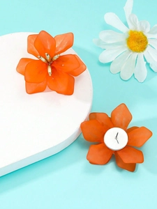 Detailed macro view of orange floral acrylic stud earrings with matte resin finish