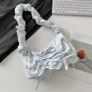 Close-up of ruched blue and white striped fabric with decorative white ribbon bows