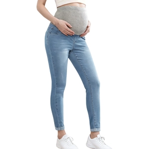 Close-up of maternity skinny jeans with high elastic belly support in light blue denim