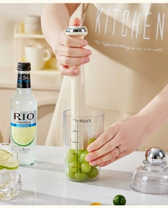 Macro shot of 500ml measuring cup and handheld muddler for cocktails and lemon tea